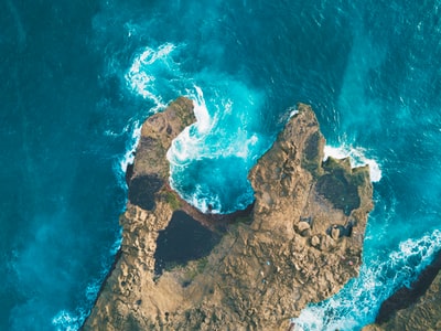 棕色岩石之间的蓝色的水域的照片
